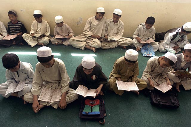 Letter of the law: Afghan boys reading the Koran at a madrassa in Ghazni province
