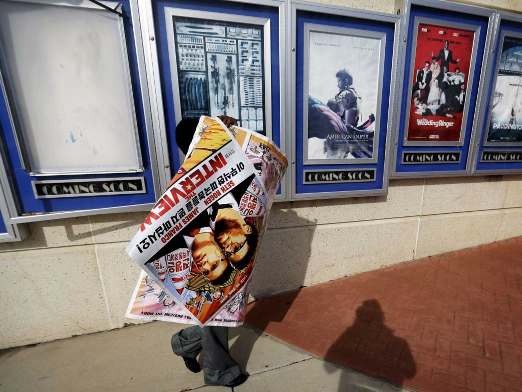 A poster for ‘The Interview’ is destined for a bin after being pulled from a display at a Carmike Cinema in Atlanta, Georgia