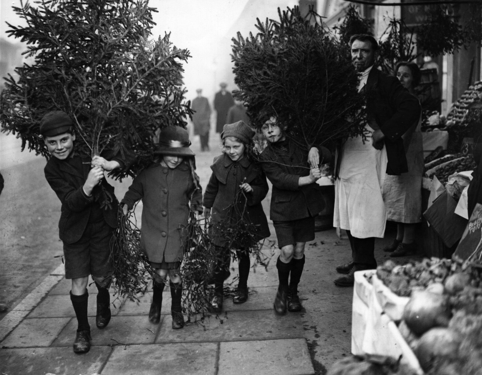 Children carry Christmas trees home in December 1923