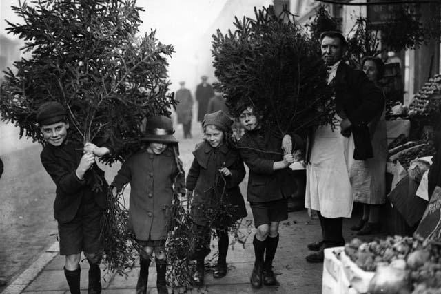 Children carry Christmas trees home in December 1923