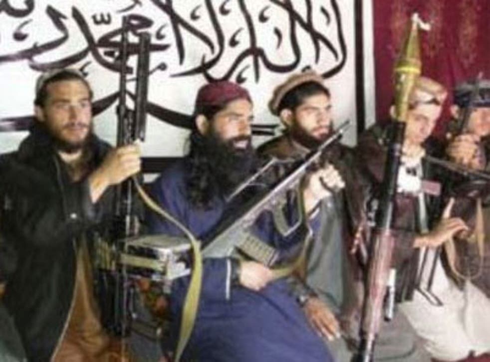 Militants, who the Pakistan Taliban say attacked the Army Public School in Pehawar on Tuesday, pose with weapons and Khalifa Omar Mansoor Hafzullah (centre in blue)
