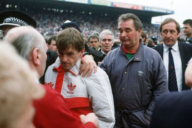 Kenny Dalglish is comforted by a police officer as he and Nottingham Forest Manager Brian Clough leave Hillborough on 15 April 1989