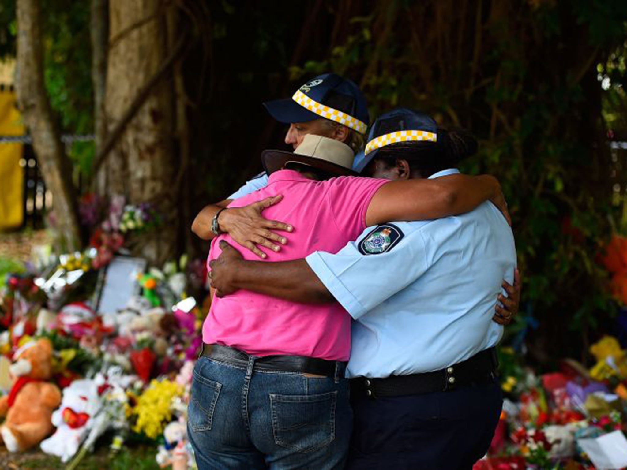 A neighbour is comforted near the house where eight children died