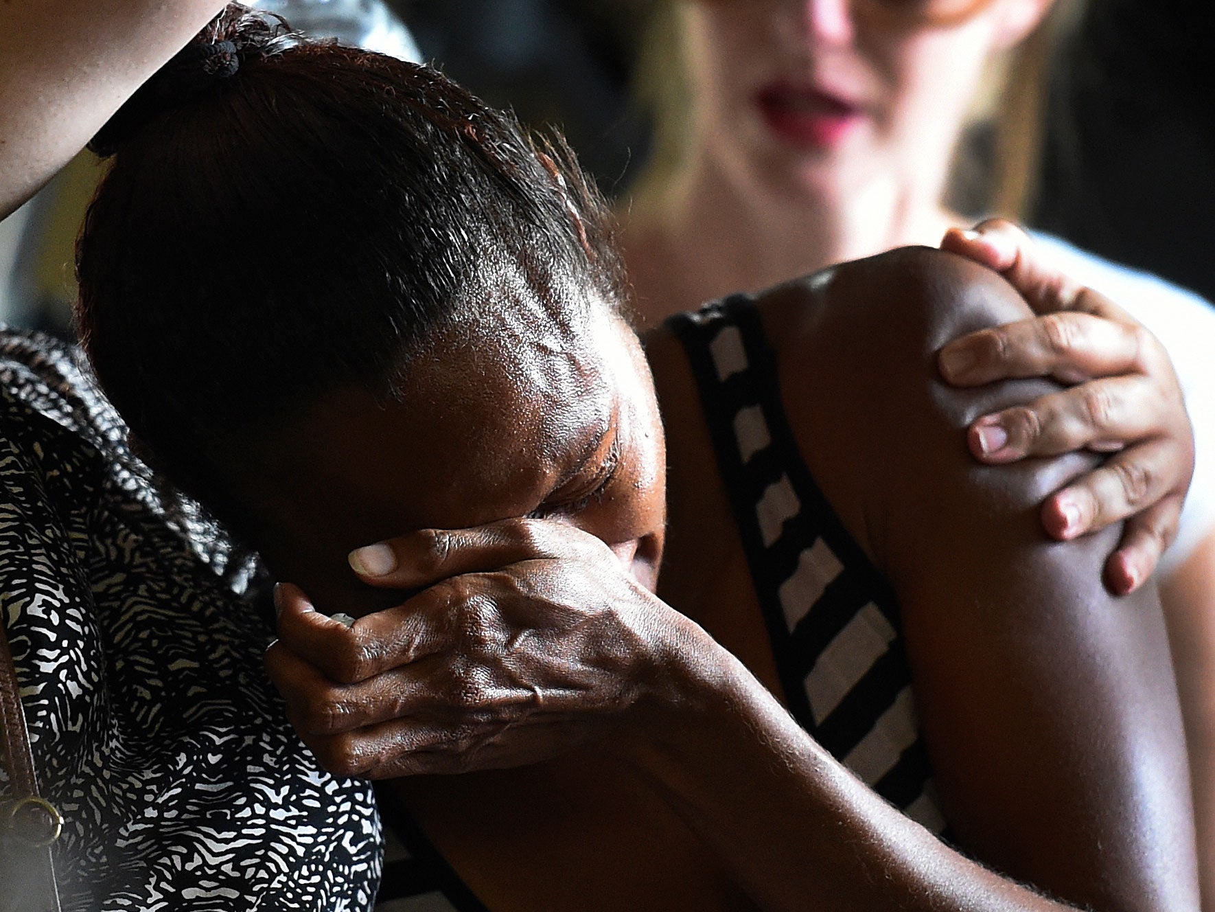 A woman cries during a church service to remember the eight children who were killed on Friday