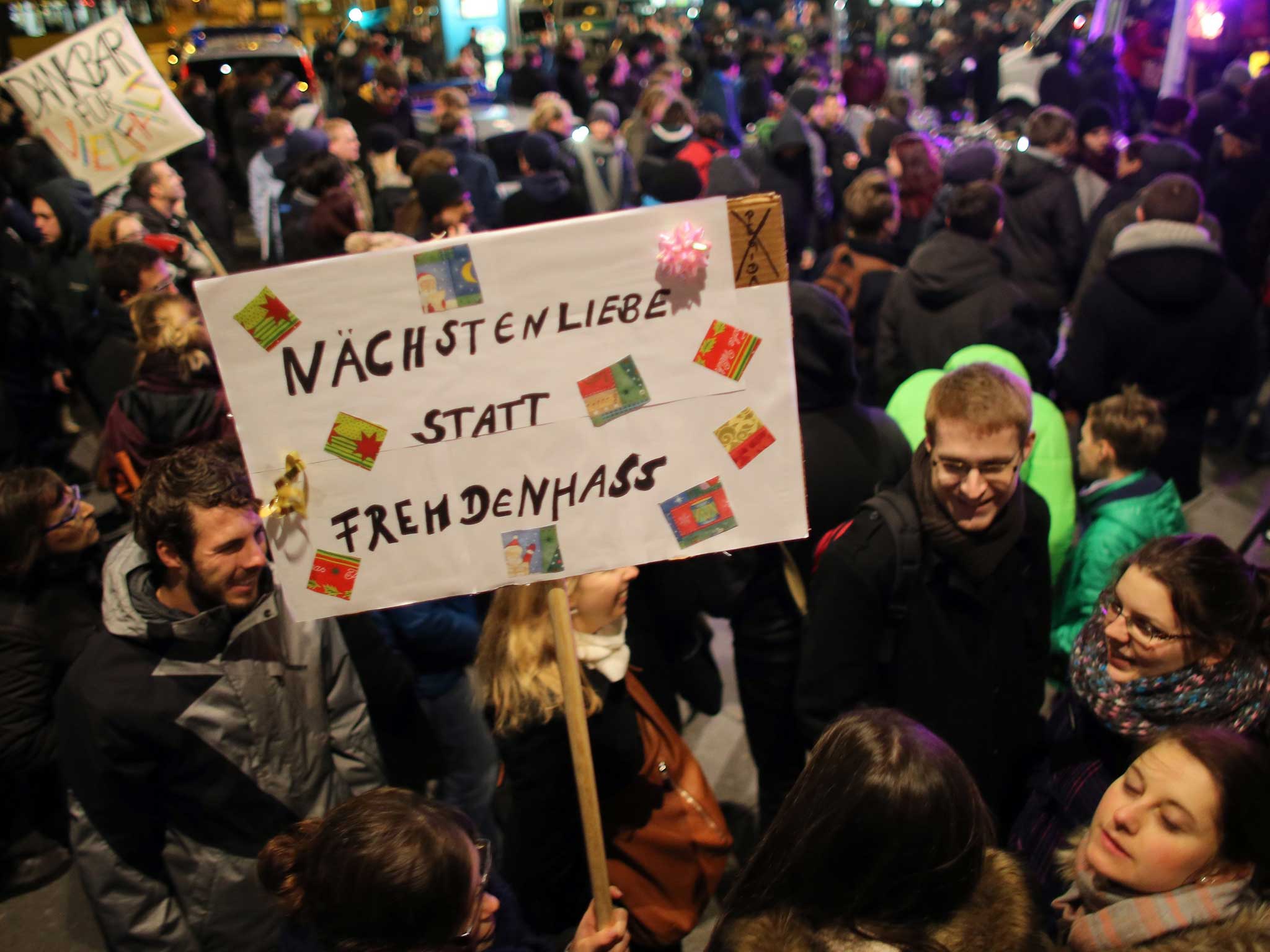 An anti-Pegida protester holds a banner reading "love not xenophobia"