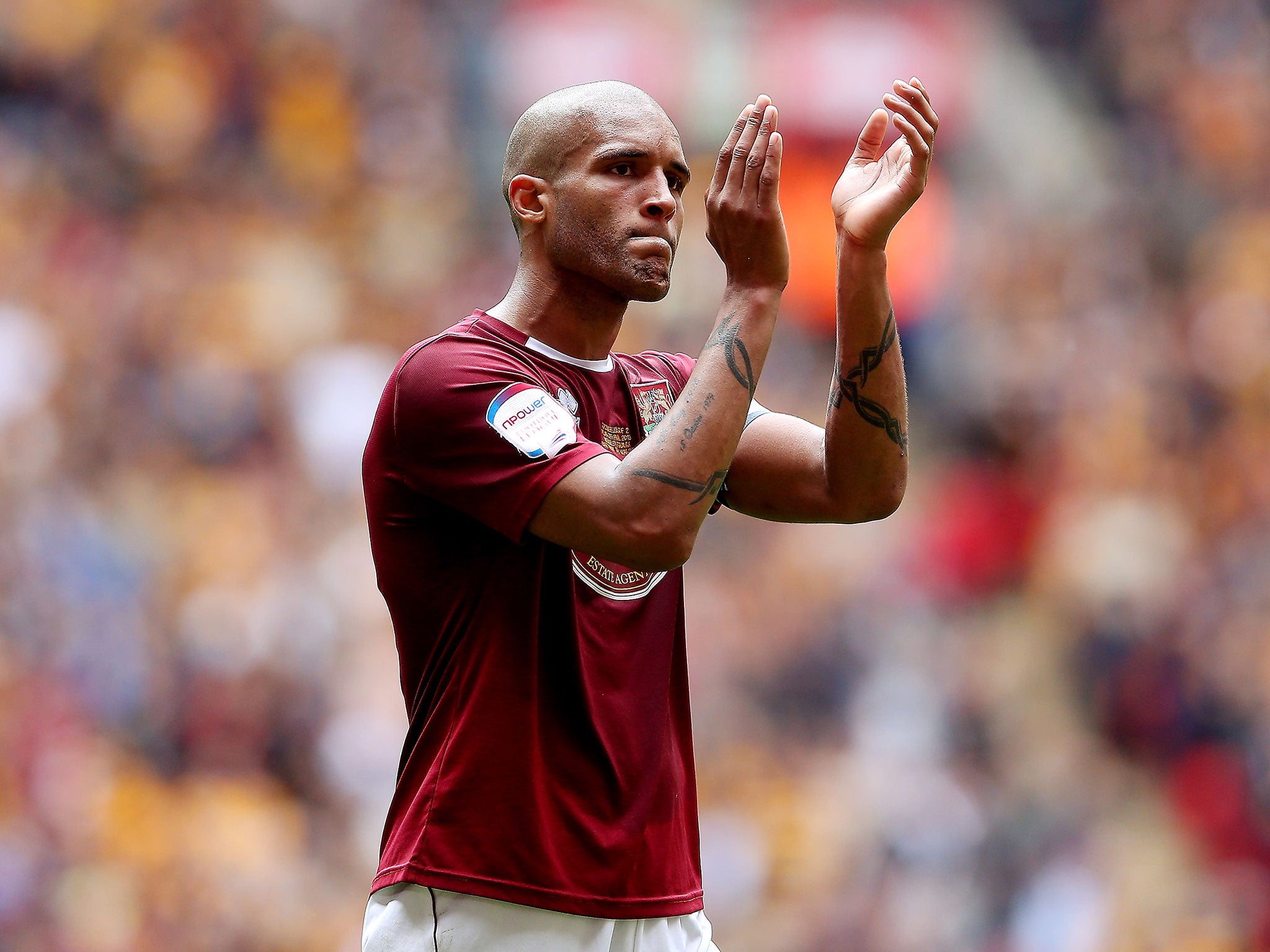 Clarke Carlisle applauds the Northampton fans in his final appearance before retirement