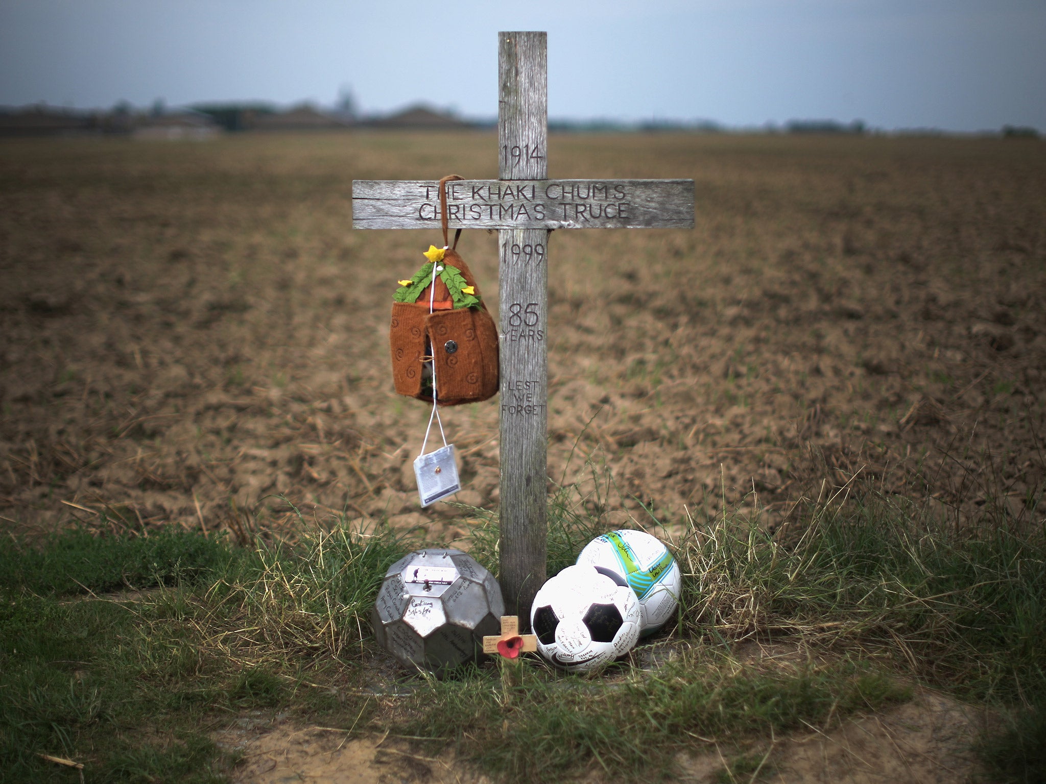 A simple wooden memorial cross marks the field outside Ploegsteert Wood, where British and German soldiers played football during the World War One Christmas Day truce in 1914 (Getty)