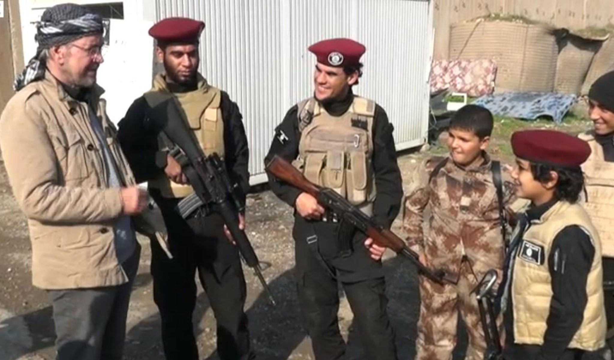 Mr Todenhoefer (far left) met with child fighters equipped with guns Mosul