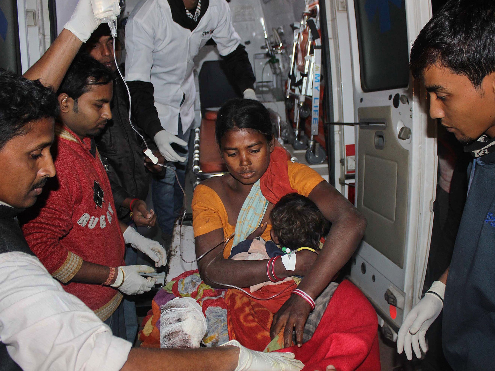 An injured women and her child arrive at a hospital in the Sonitpur district of Assam on December 23, 2014.