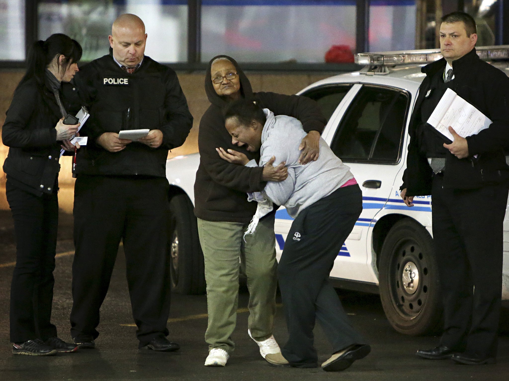 Toni Martin, front center, cries out as she talks to the police at the scene where she says her son was fatally shot