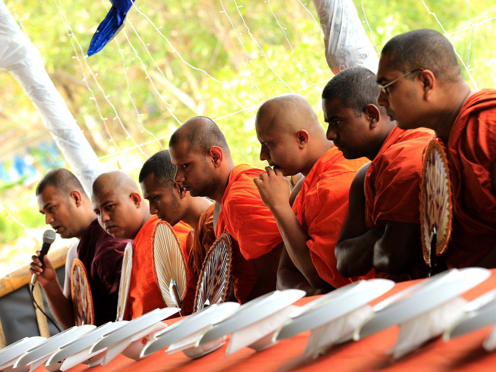 Sri Lankan Buddhist monks attend the alms giving ceremony for remembrance and prayer for the victims of the 2004 Boxing Day tsunami