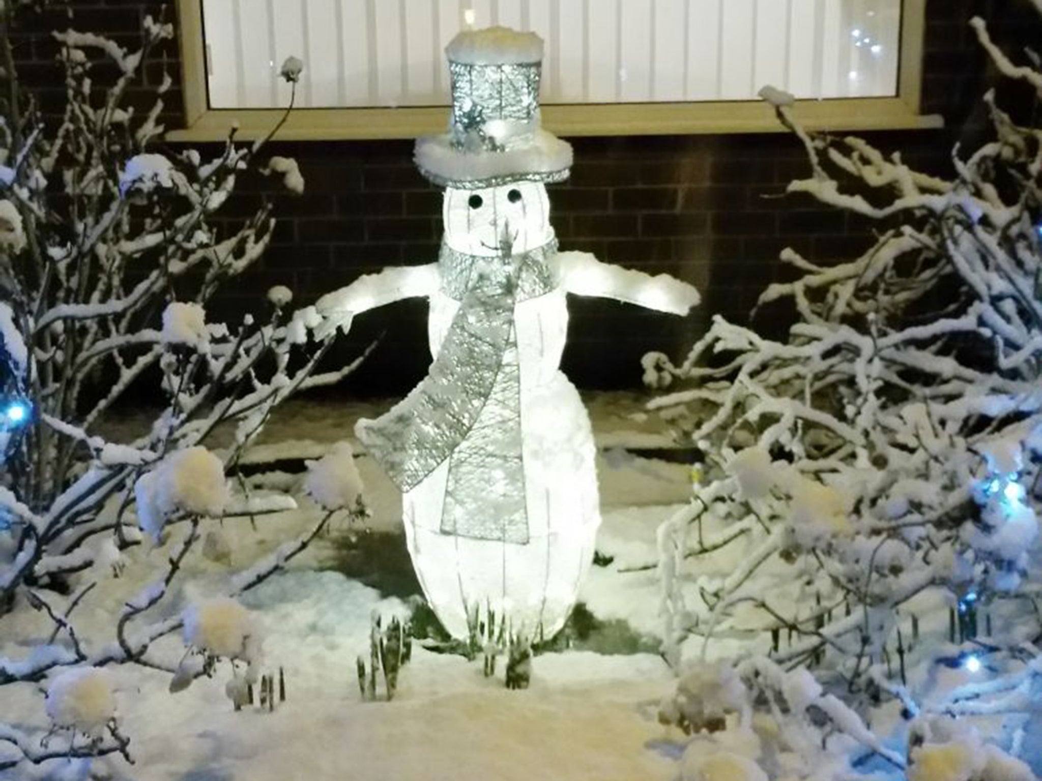 A decorative snowman surrounded by real snow outside a house in Eccleston Park, near Prescot, Merseyside