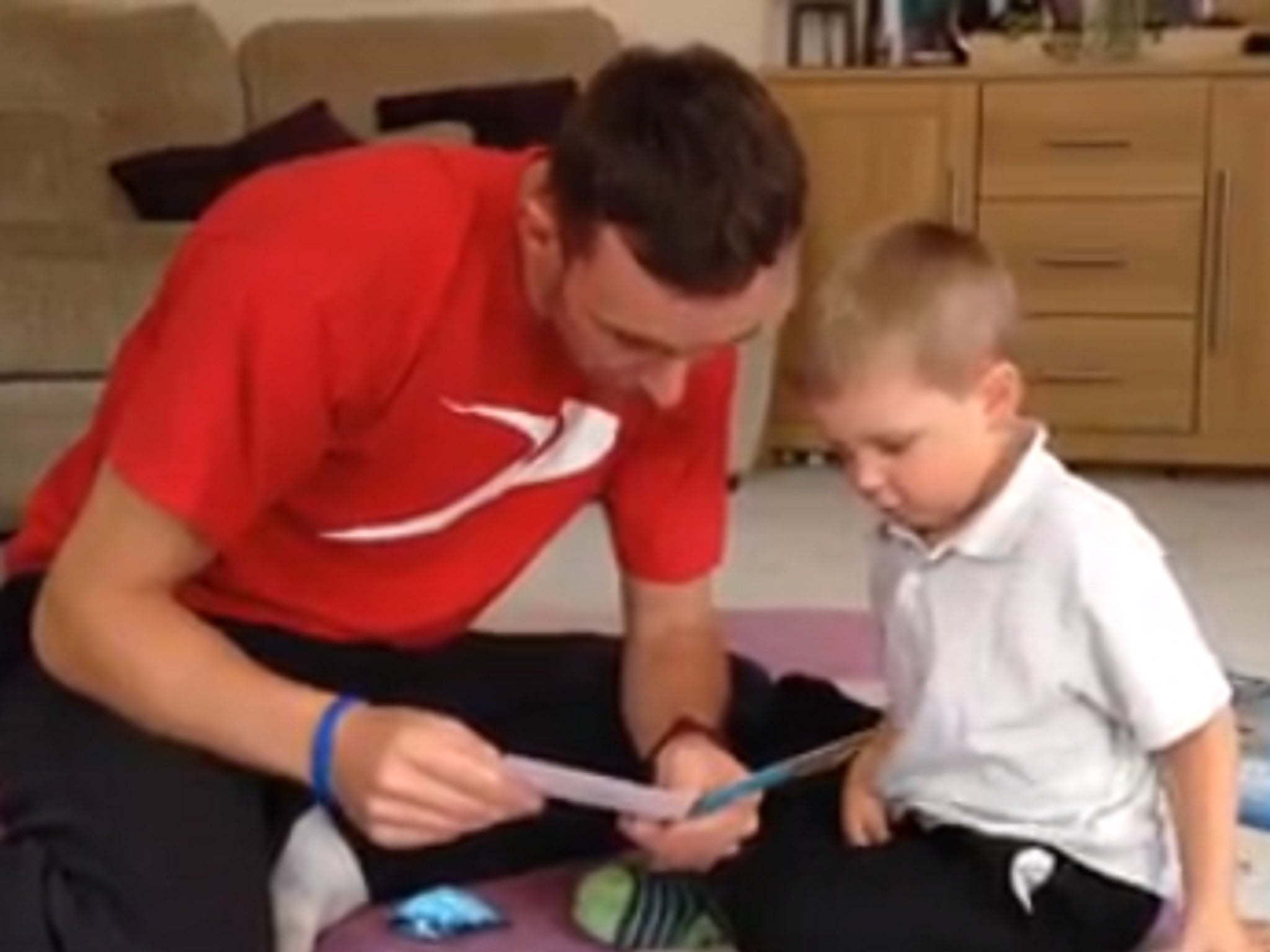 Jayden with his dad Mike reading the birthday card Spiderman actor Andrew Garfield sent him