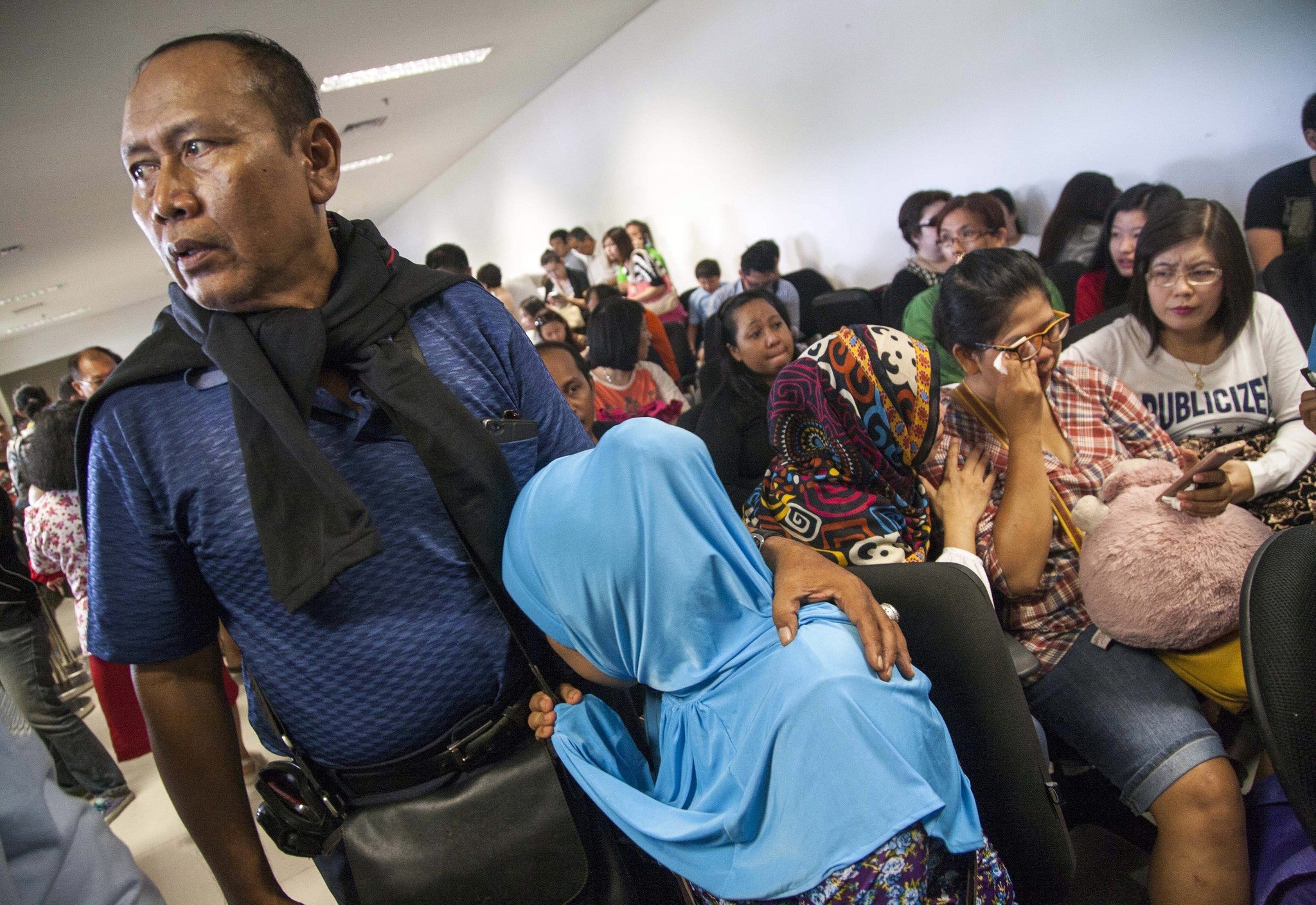 Concerned relatives await news of the Air Asia missing plane at Juanda Airport, Surabaya, Indonesia