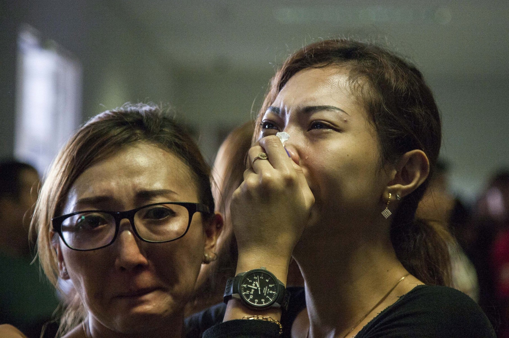 Weeping relatives await news of the Air Asia missing plane at Juanda Airport, Surabaya, Indonesia