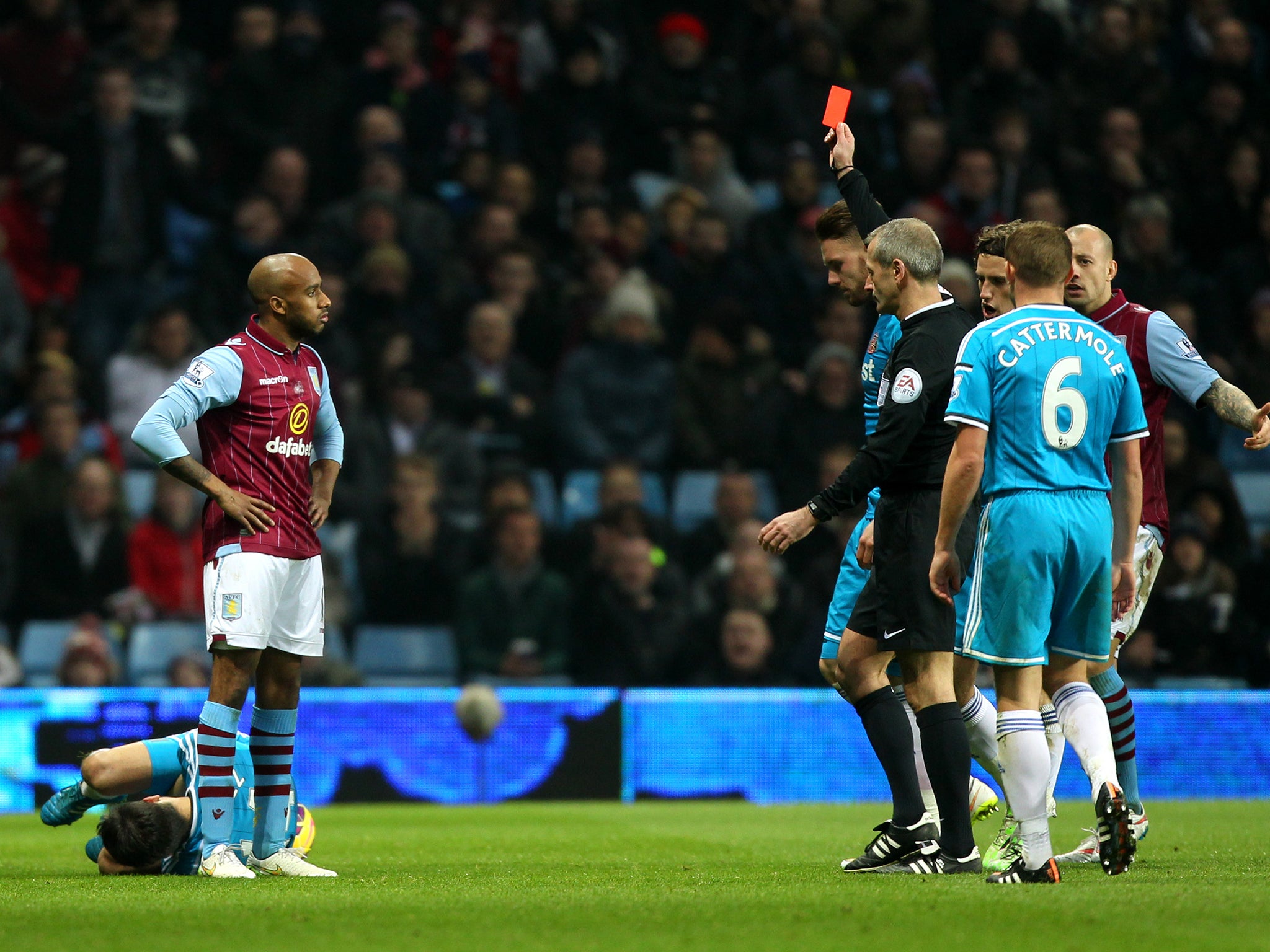 Fabian Delph of Aston Villa receives a red card from referee Martin Atkinson