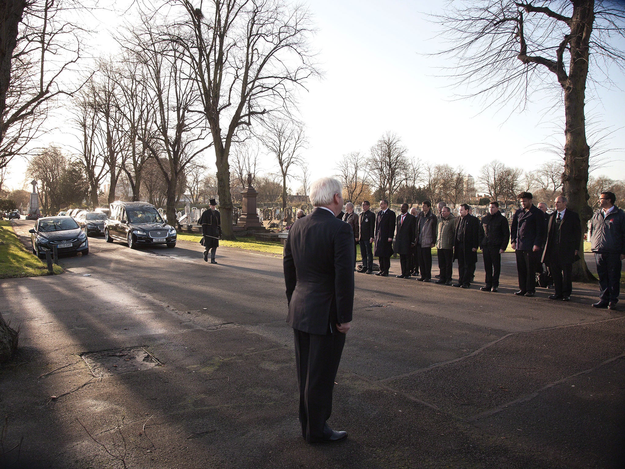 Mourners stand to attention to honour Ian Douglas