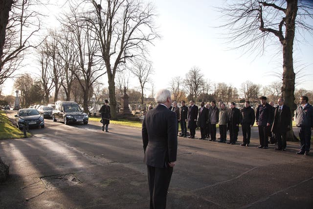 Mourners stand to attention to honour Ian Douglas