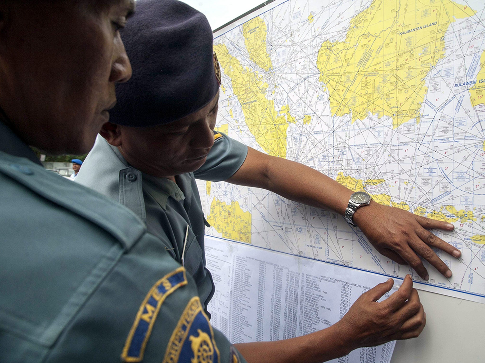 Indonesian Navy soldiers install maps showing the search area for the missing AirAsia flight, at Juanda Airport, in Surabaya, Indonesia