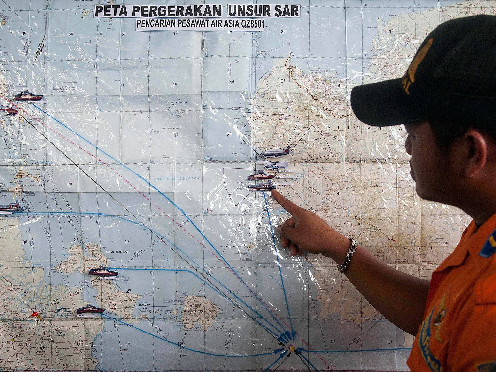 A search and rescue officer assesses a co-ordination map of Indonesia
