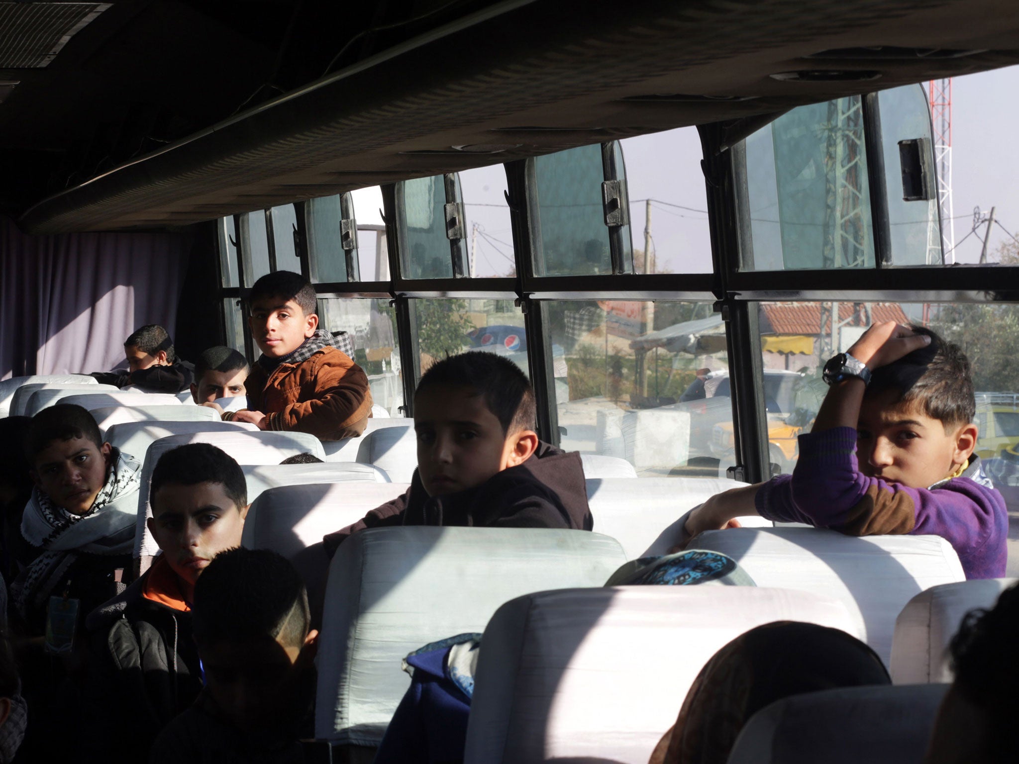 Palestinian children wait on a bus at Erez crossing in Beit Hanun in the north of the Gaza Strip on December 28, 2014, before being prevented by Hamas from entering Israeli territory