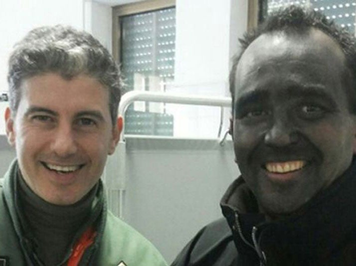 Nick Channing-Williams, covered in soot, with one of his rescuers