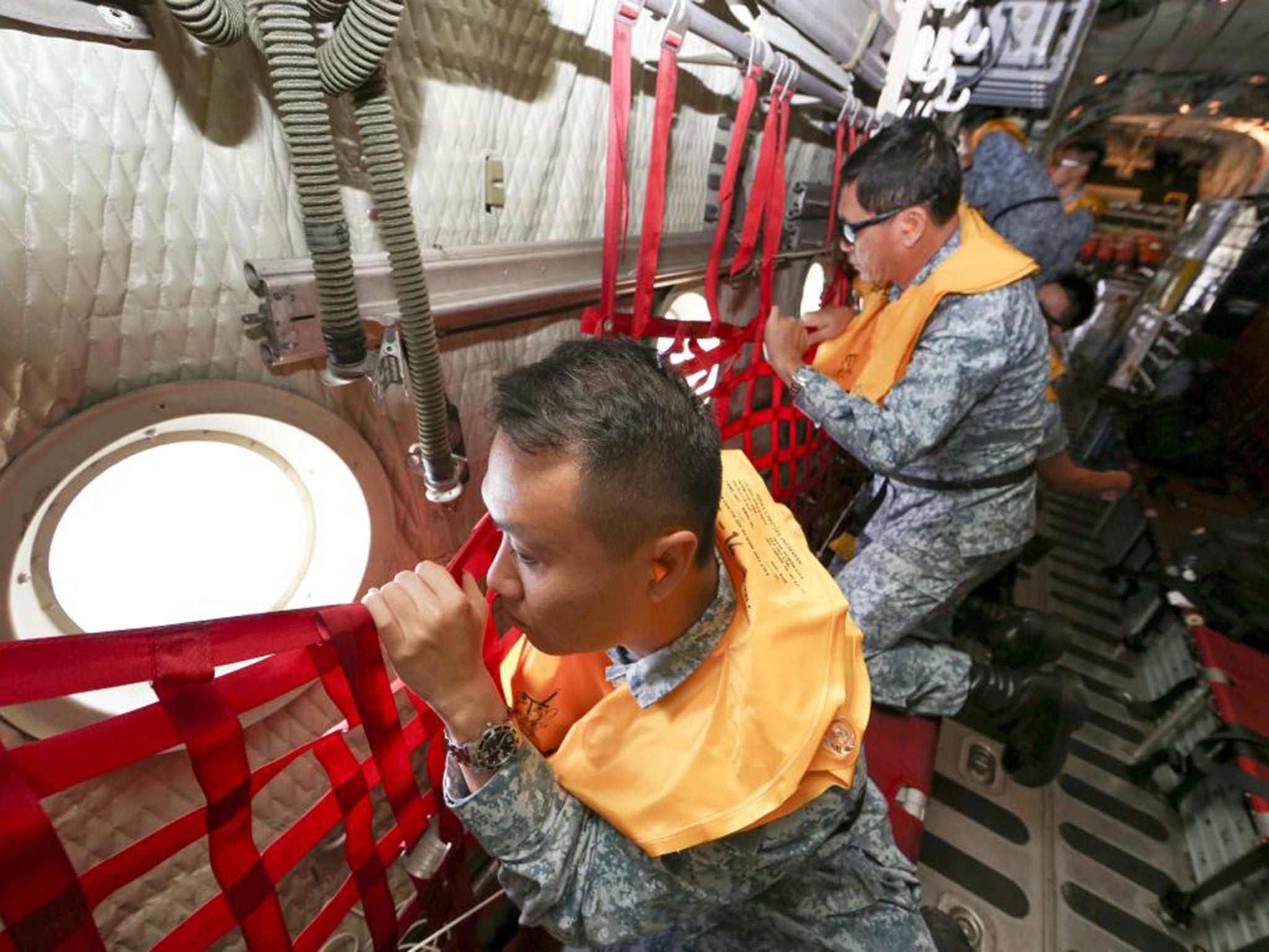 Personnel from Singapore's Air Force on board a C-130 Hercules during a search and rescue operation for the missing AirAsia flight QZ8501