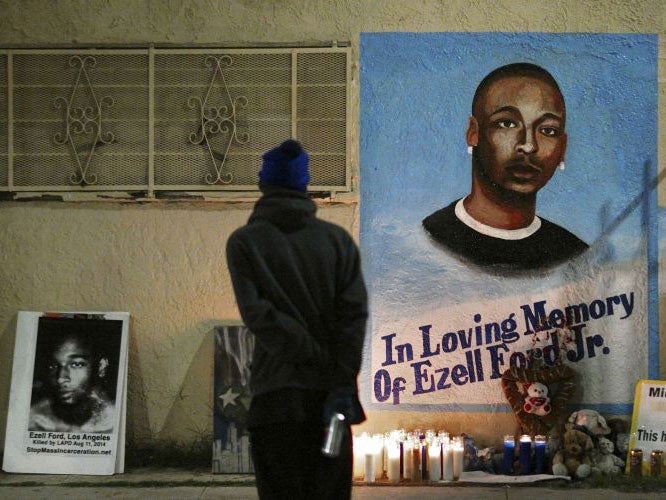 A man stands near a mural for Ezell Ford after the Los Angeles County Coroner released an autopsy report on 29 December 2014