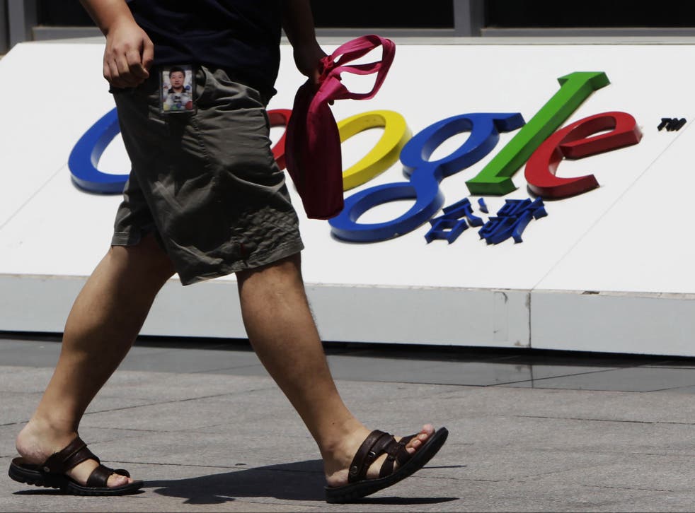 An employee walks past the logo of Google in front of its former headquarters, in Beijing June 2, 2011