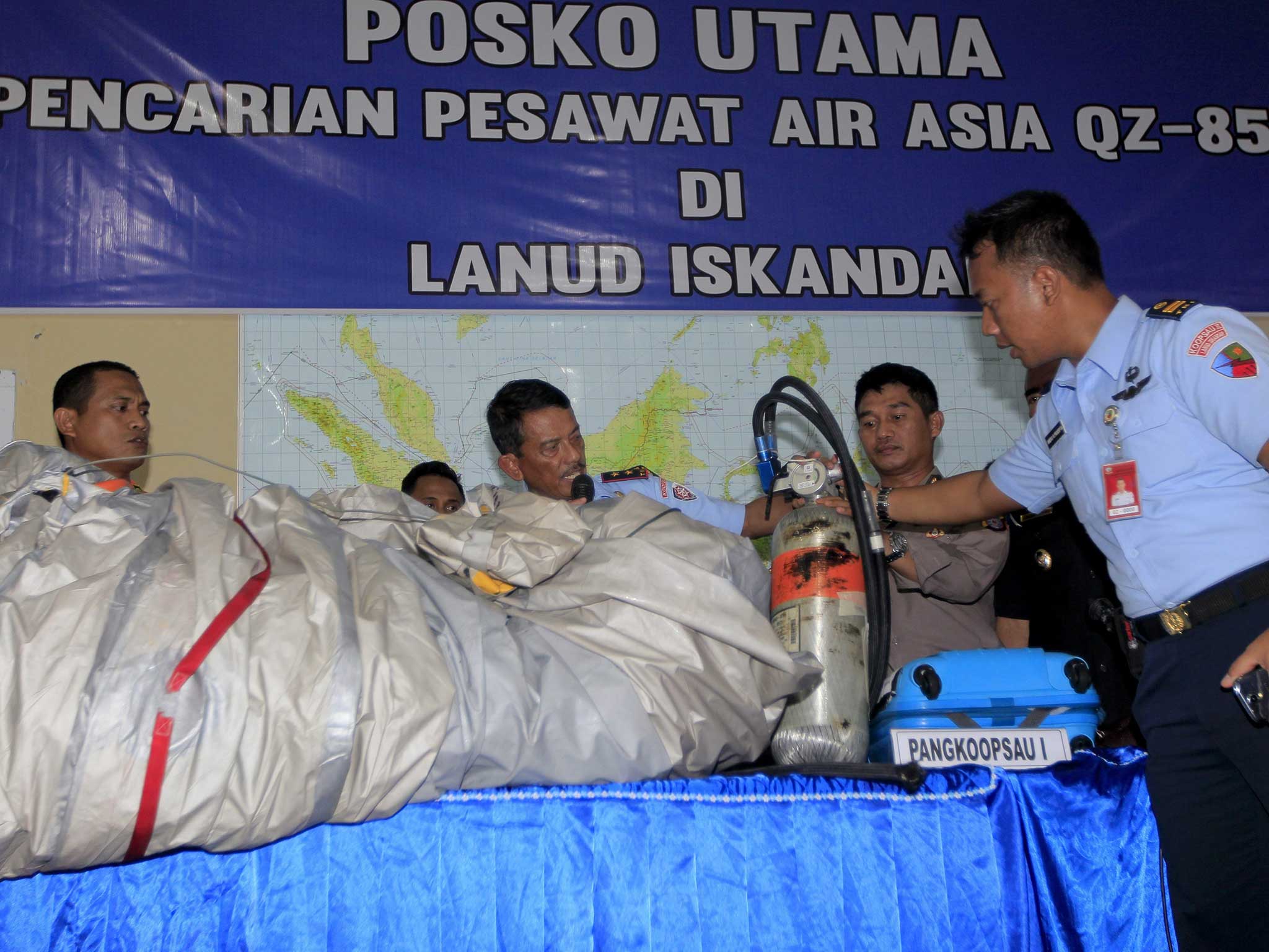 akarta's Air Force base commander Rear Marshal Dwi Putranto (C) and Indonesian Air Force crew show pieces recovered from the wreck