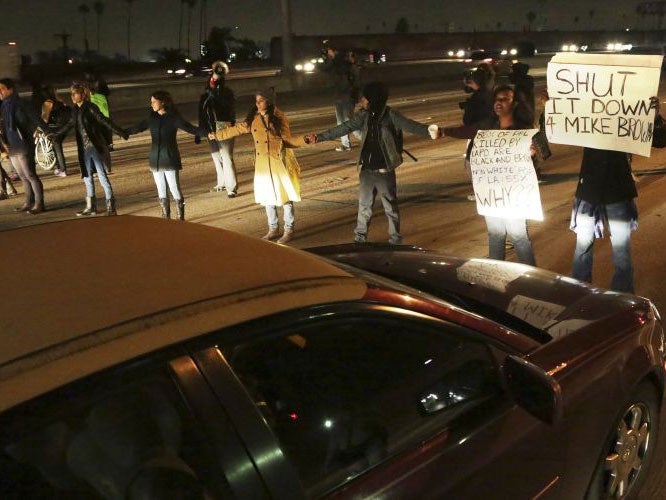 Protesters block southbound lanes of 110 freeway after the Los Angeles County Coroner released Ezell Ford's autopsy report