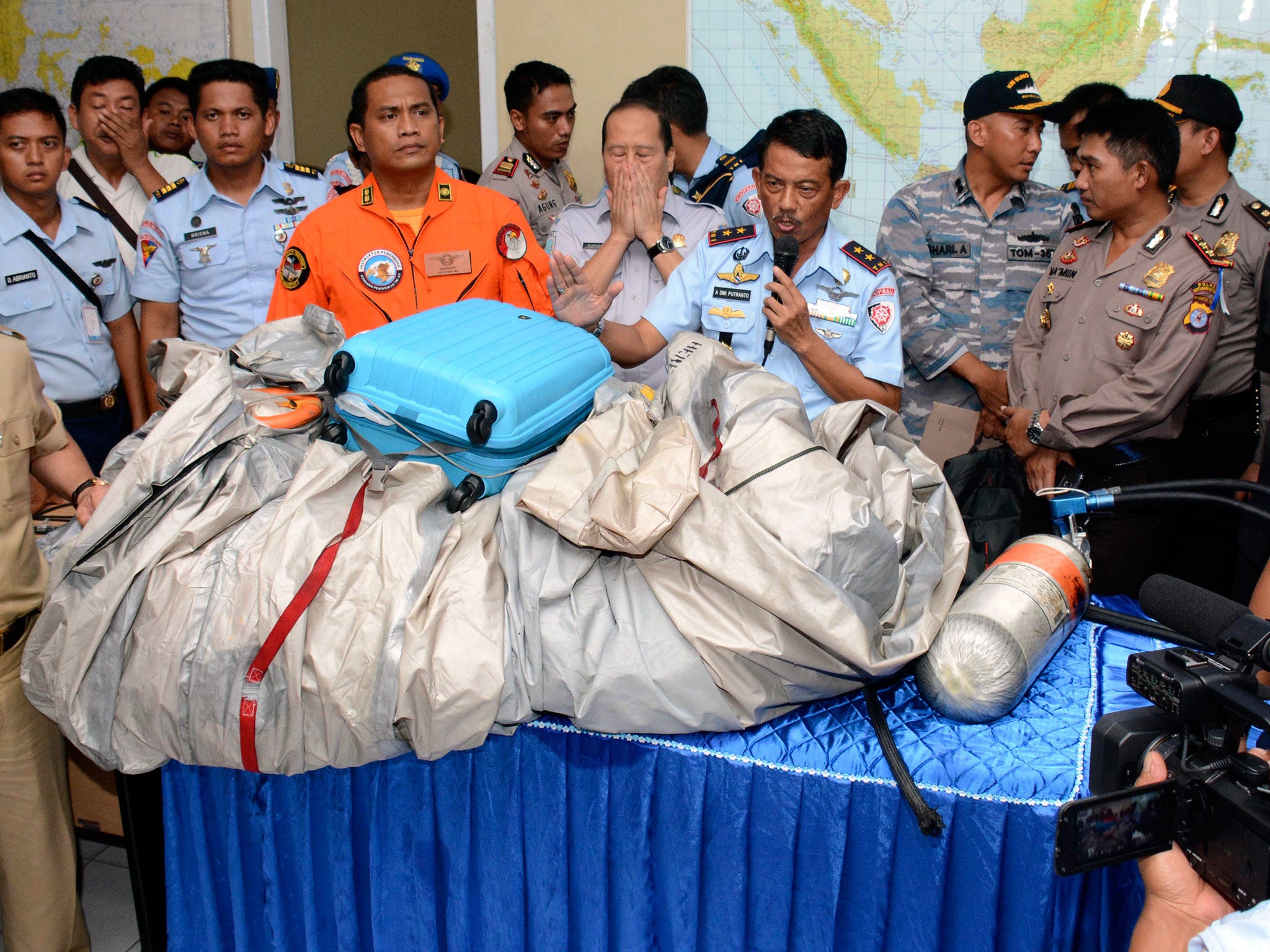 Commander of Indonesian Air Force 1st Operational Command Rear Marshall Dwi Putranto, center, shows the airplane parts and a suitcase found floating on the water near the site where AirAsia Flight 8501 disappeared, during a press conference at the airbase in Pangkalan Bun, Central Borneo, Indonesia