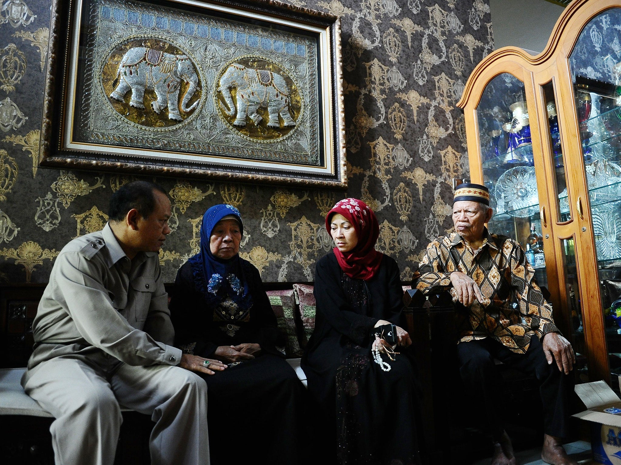 Captain Irianto's (the pilot of AirAsia QZ8501 flight) relatives and his wife Widiya Sukati (3rd L) Putri gather in his house at Sidoarjo in Surabaya, Indonesia