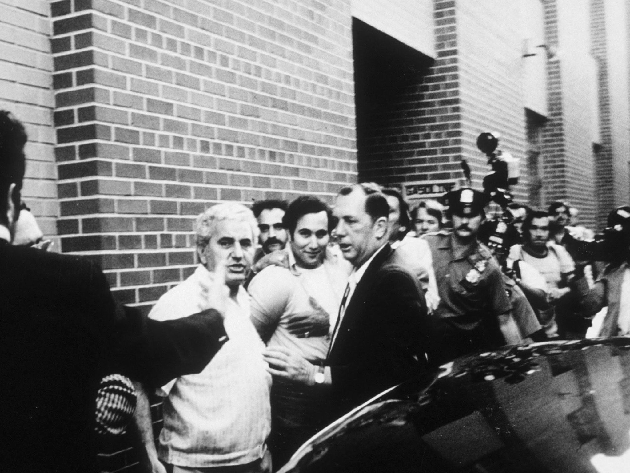 Serial killer David Berkowitz surrounded by police and reporters
