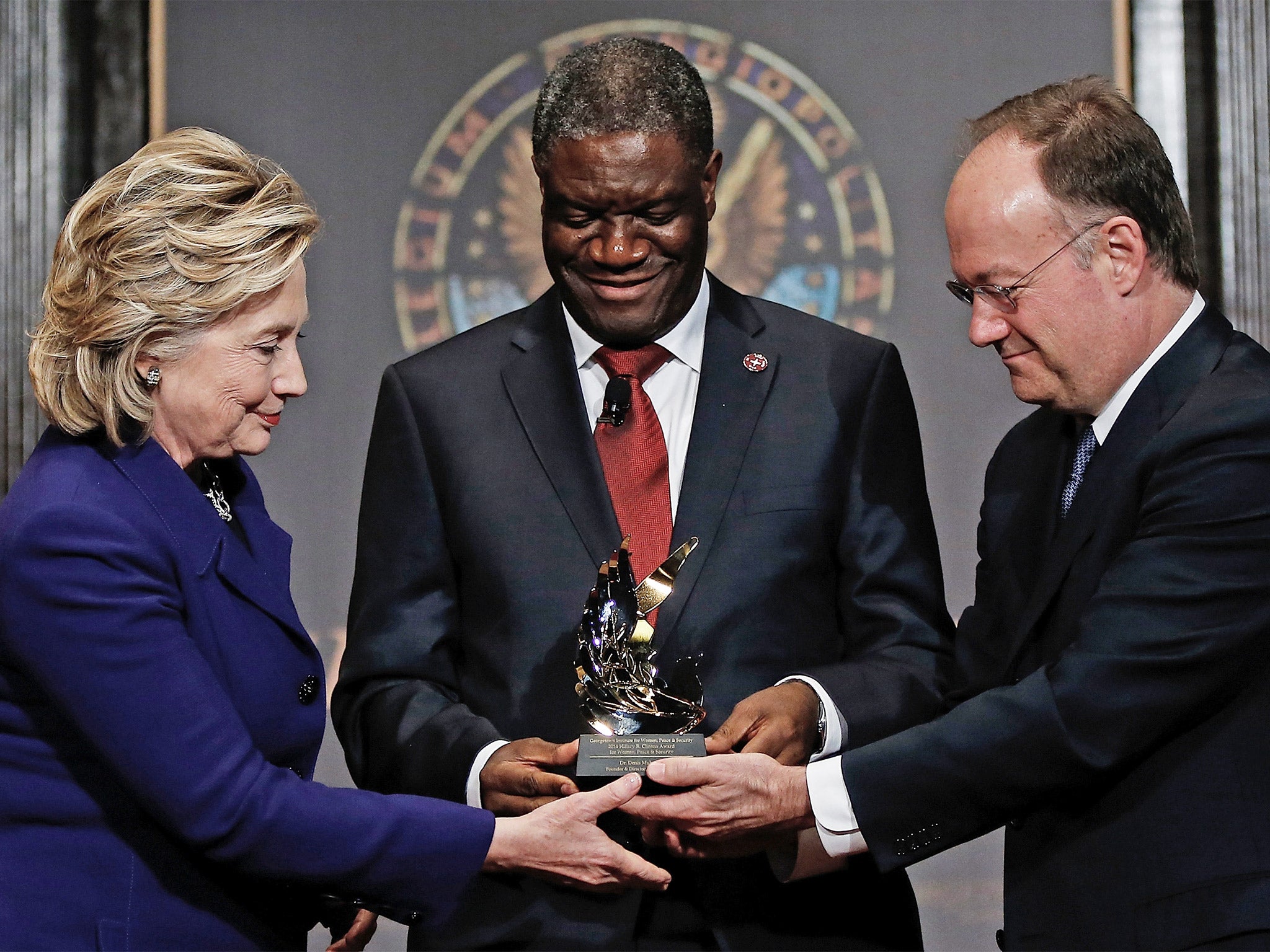 Force for good: Dr Denis Mukwege receives a humanitarian award from Hillary Clinton and Georgetown University head, John De Gioia