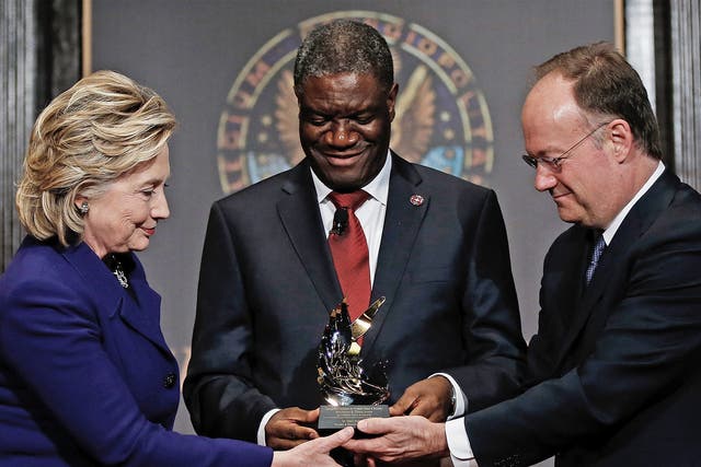 Force for good: Dr Denis Mukwege receives a humanitarian award from Hillary Clinton and Georgetown University head, John De Gioia
