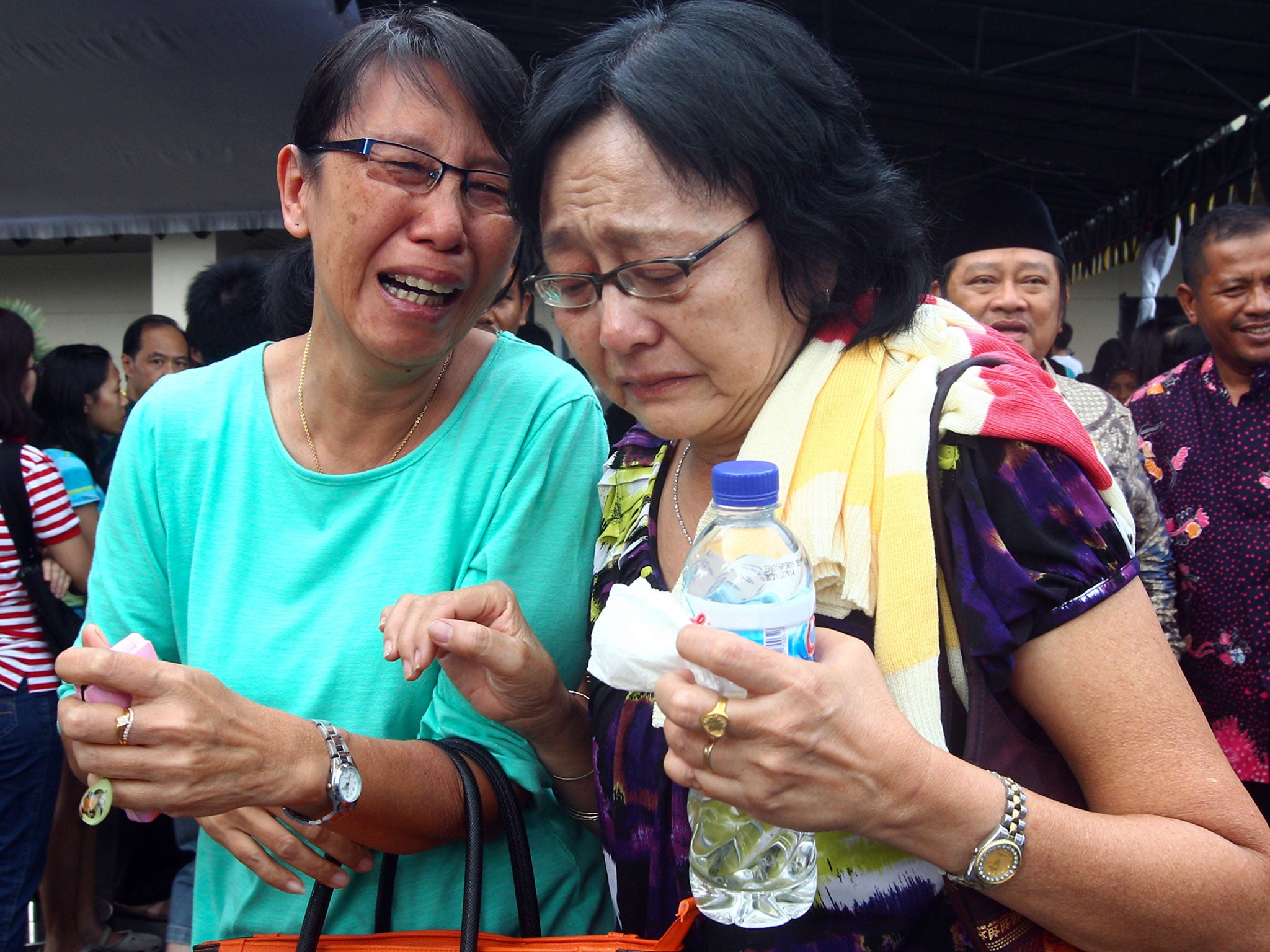 Relatives of passengers of AirAsia Flight 8501 cry after visiting the crisis center at Juanda International Airport in Surabaya, East Java, Indonesia