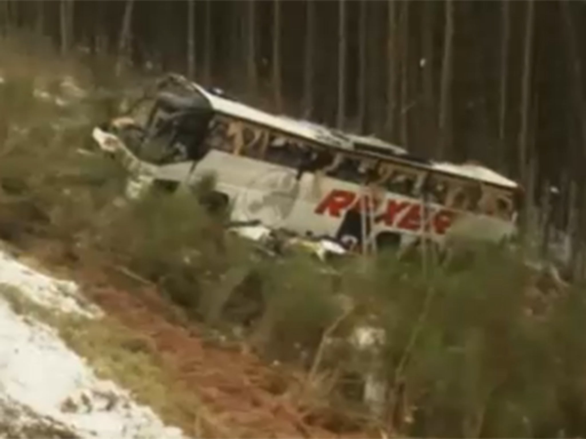 The bus lies by the side of the road after the crash