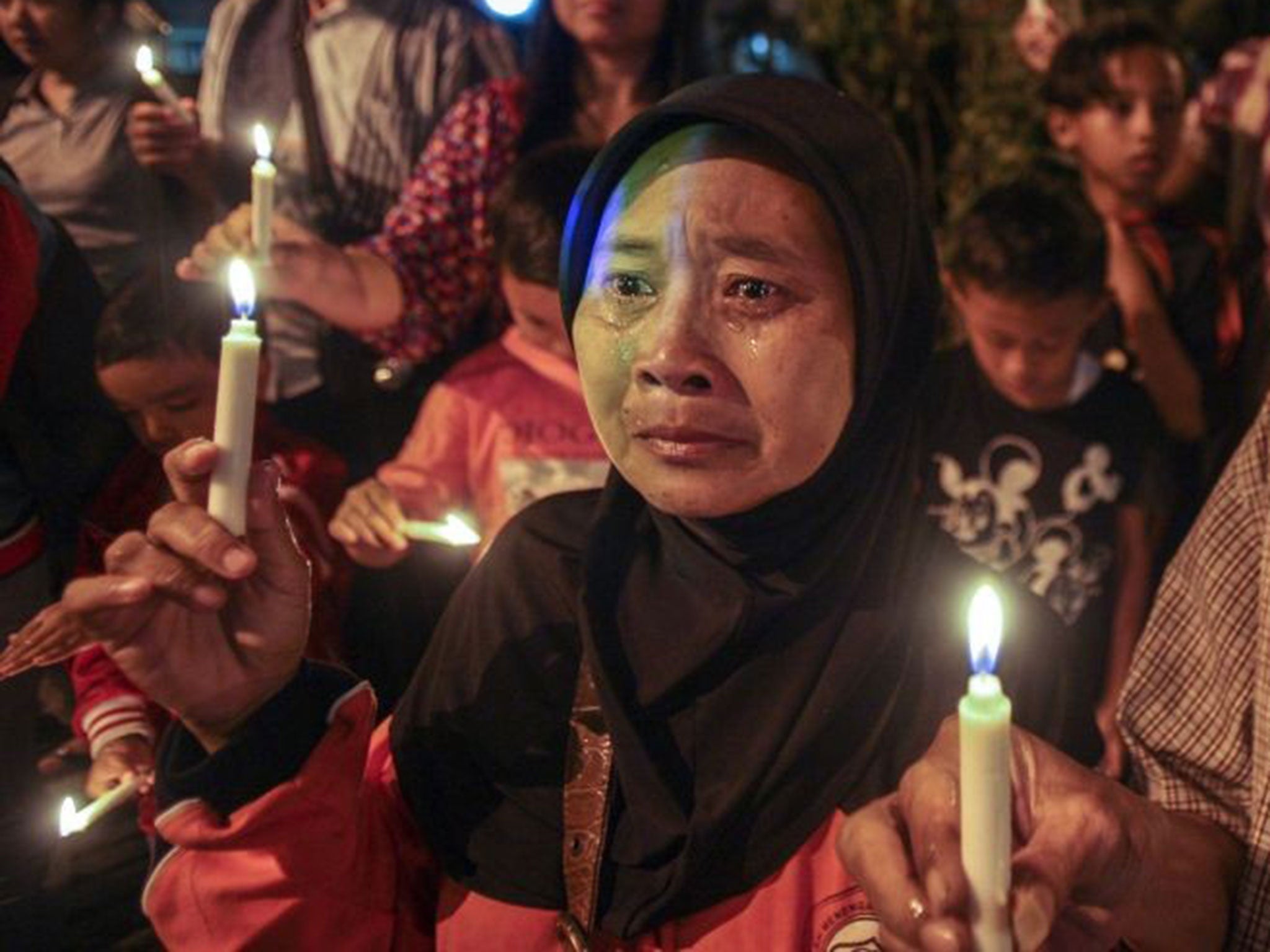 An Indonesian woman cries as she holds a candle during a vigil for the victims in Surabaya