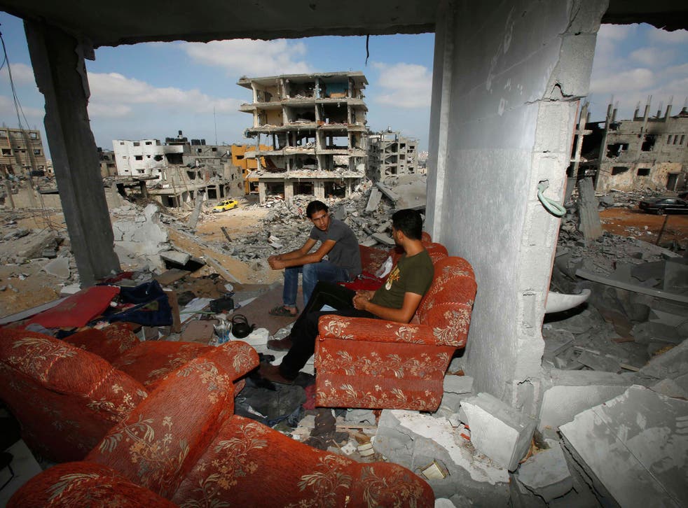 Palestinians sit on a couch as they return to the remains of their house, which witnesses said was destroyed in an Israeli offensive in Gaza City