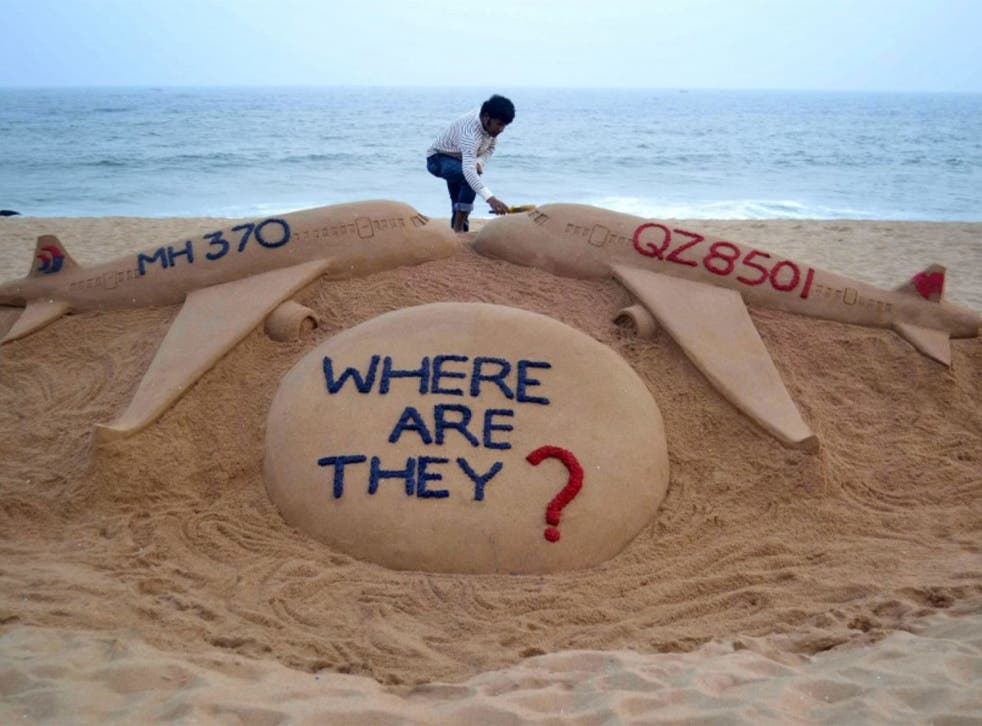 Indian sand artist Sudarsan Pattnaik gives the final touches to a sand sculpture on December 29, 2014
