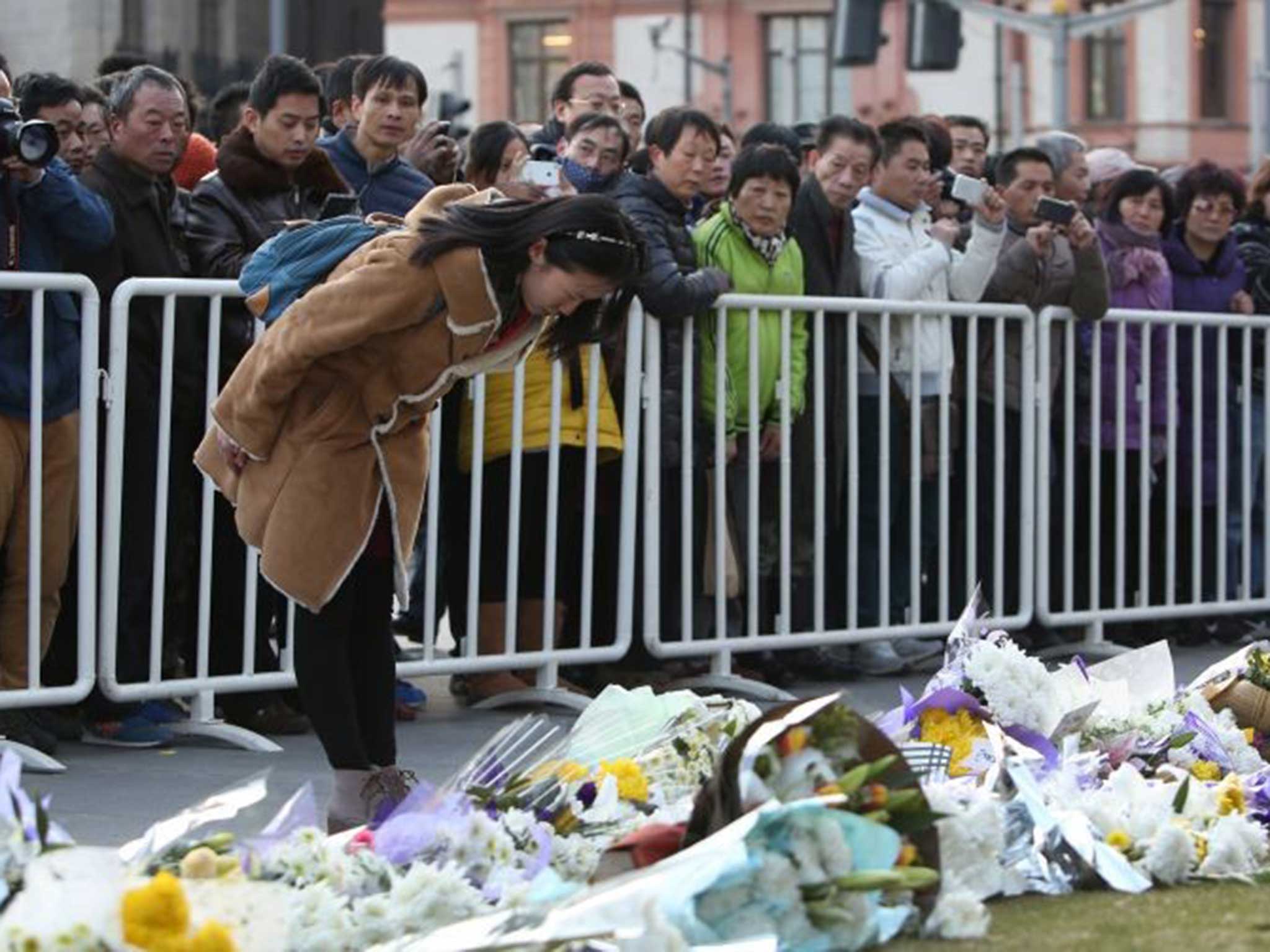 People mourn the victims of the New Year stampede. At least 35 people were killed in the Bund area in central Shanghai