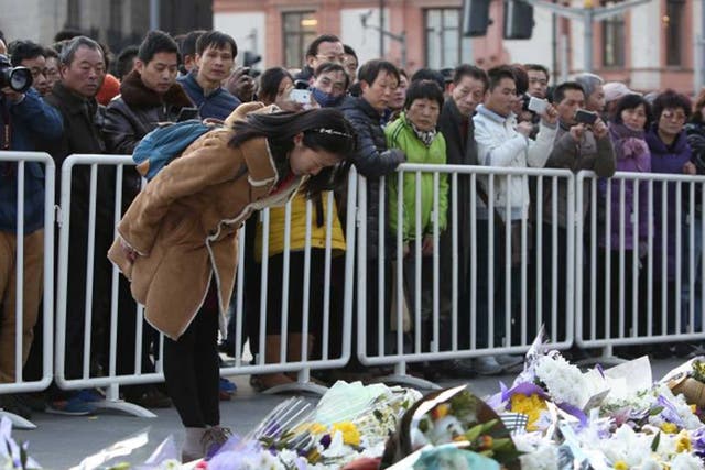 People mourn the victims of the New Year stampede. At least 35 people were killed in the Bund area in central Shanghai