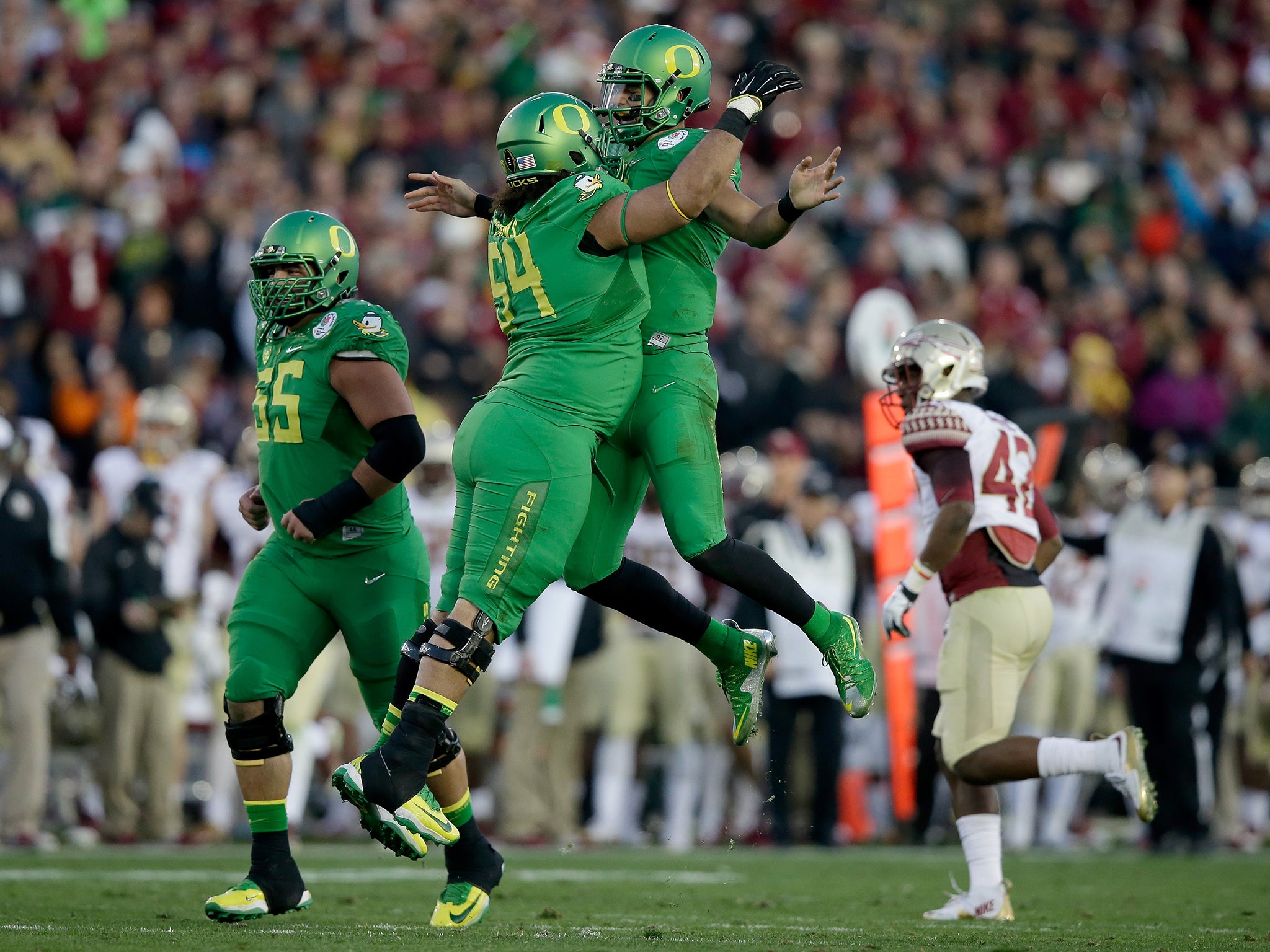 Quarterback Marcus Mariota #8 of the Oregon Ducks celebrates with offensive lineman Tyler Johnstone #64 