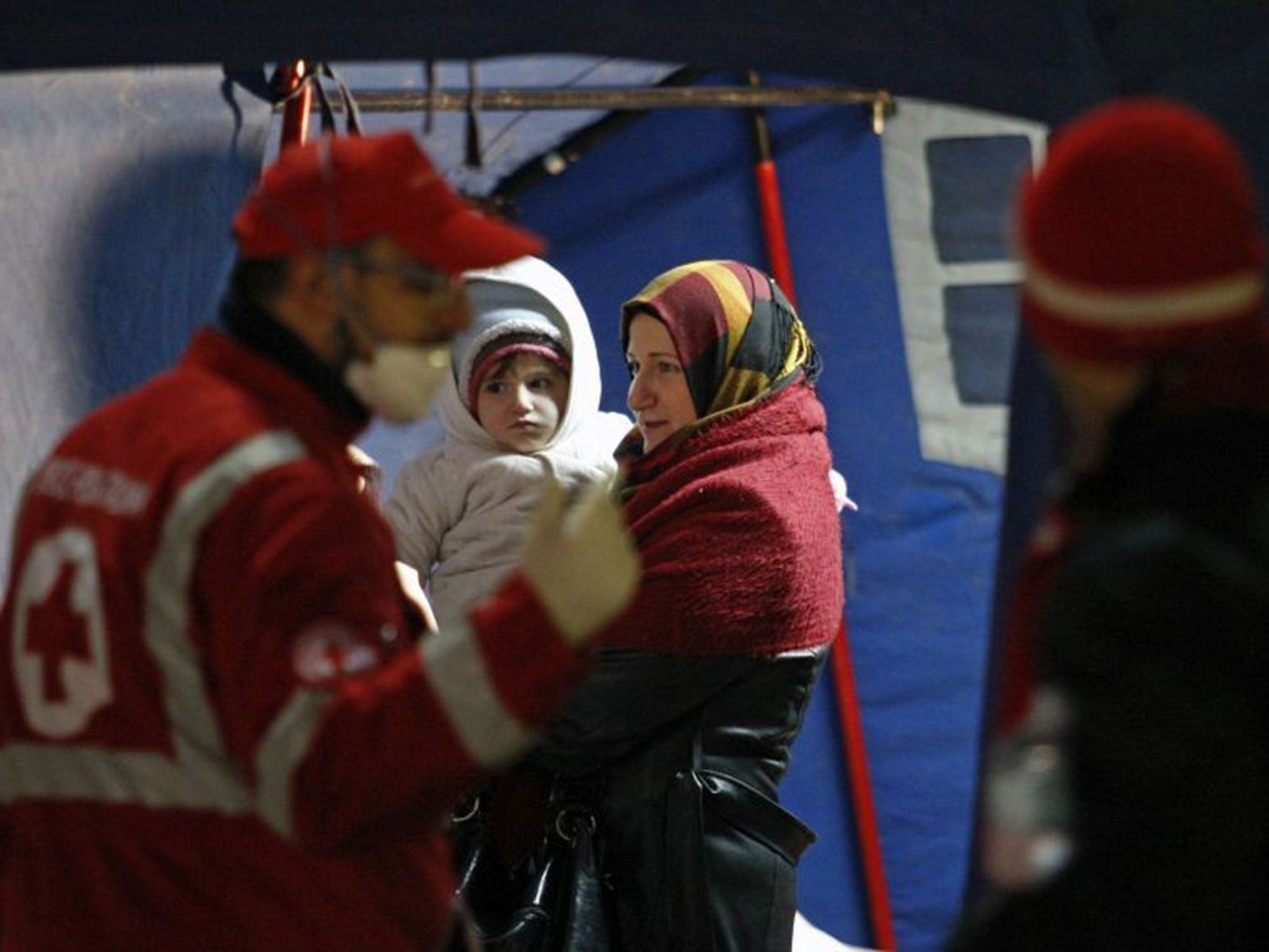 Migrants receive medical assistance after disembarking from the Ezadeen at the Corigliano Calabro harbour on 3 January