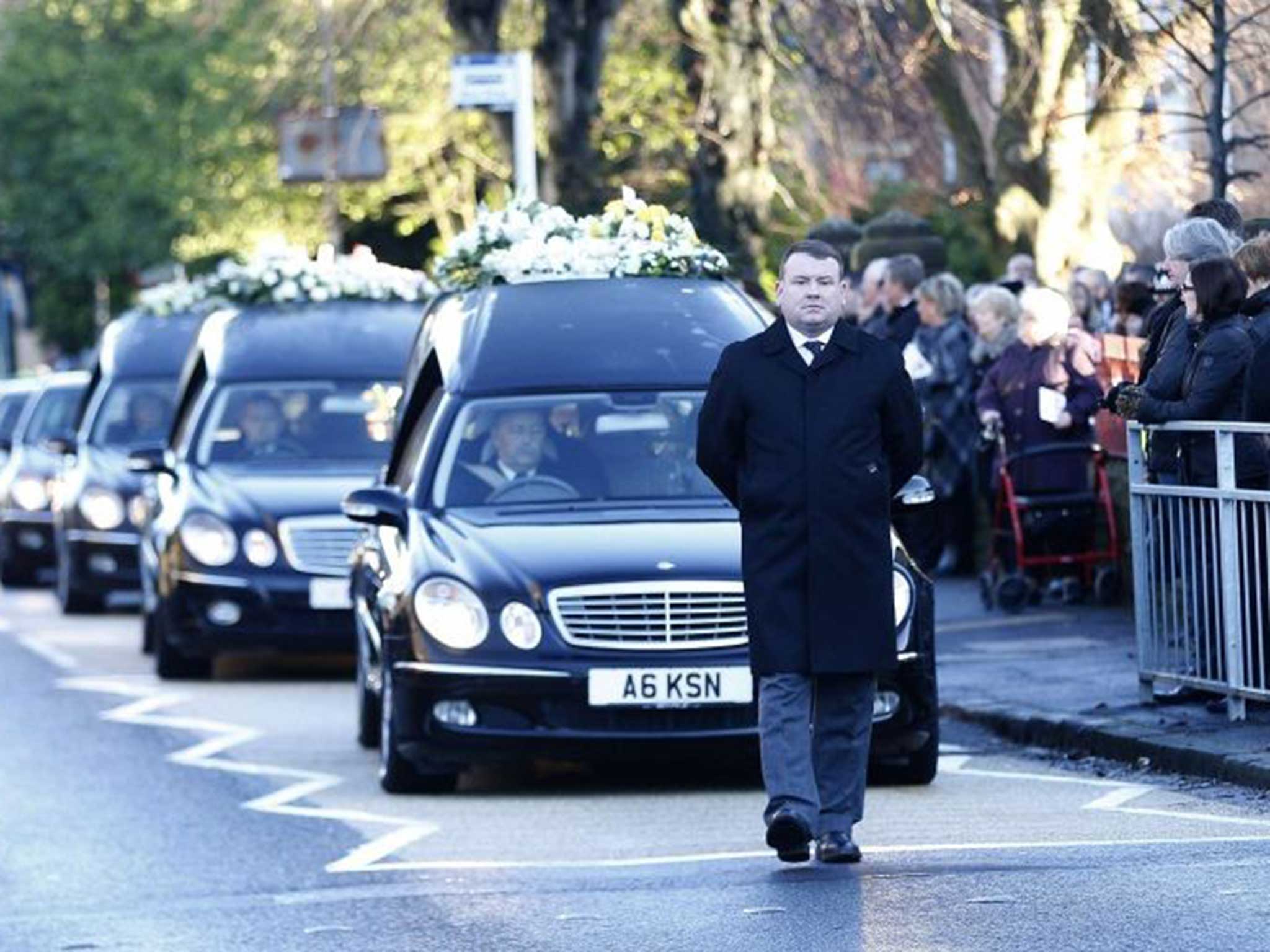 Mourners line the street after the requiem mass for Erin McQuade, Lorraine Sweeney and Jack Sweeney