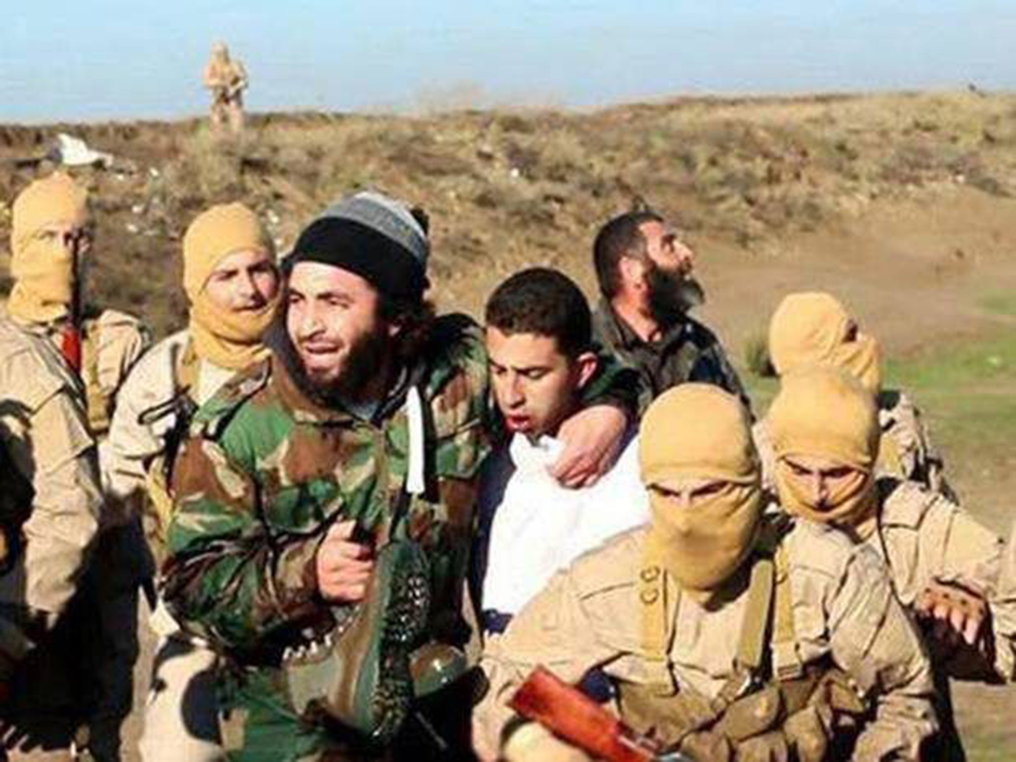 Isis fighters with downed Jordanian pilot Muath al-Kaseasbeh, shortly after his capture