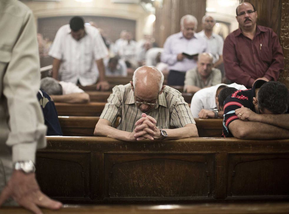 A Coptic Egyptian prays in Cairo over Christmas - the religious sect has faced widespread discrimination