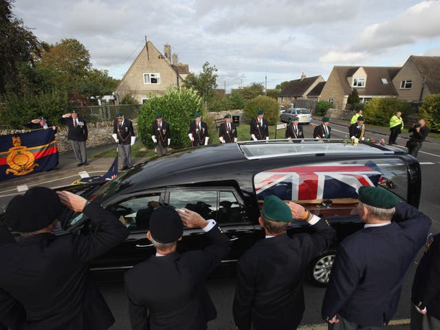 Retired Royal Marine personnel salute as a hearse passes through the village of Brize Norton in 2011 (Getty)