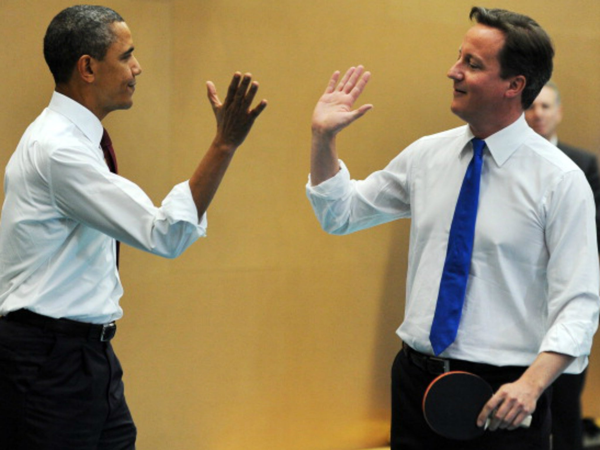High five: Obama and Cameron playing table tennis at the Globe Academy School in London 2011